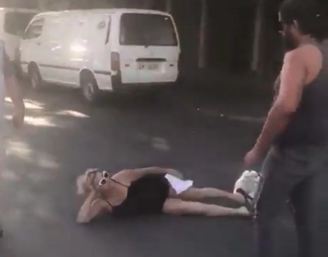 شاهد.. امرأة لبنانية تفترش الطريق بجسدها وتمنع مرور السيارات: “أنا هون بدي أقطع”