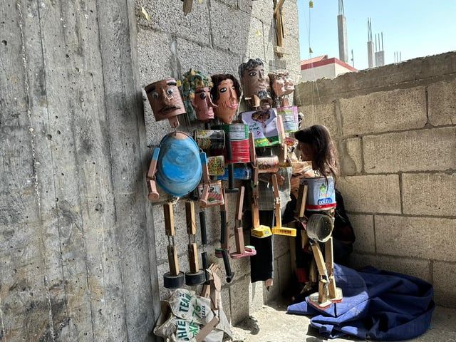 غزة.. فنّان يصنع من عبوات المساعدات دمى لإسعاد الأطفال (صور)