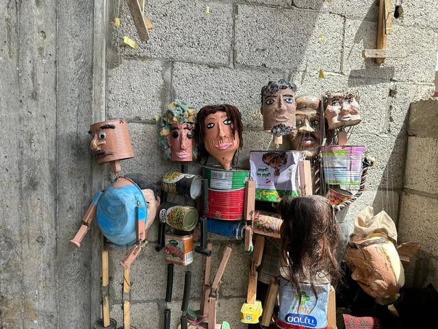 غزة.. فنّان يصنع من عبوات المساعدات دمى لإسعاد الأطفال (صور)