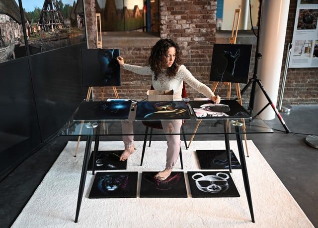 بطريقة مذهلة.. فنانة ترسم عشر لوحات في وقت واحد (صور)