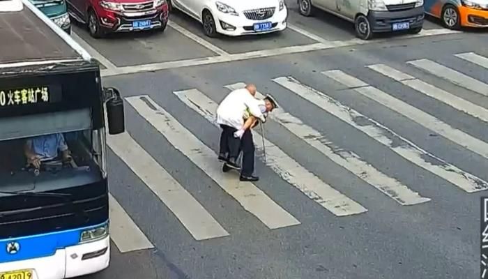 شهامة شرطي صيني مع مسنّة عالقة بالطريق