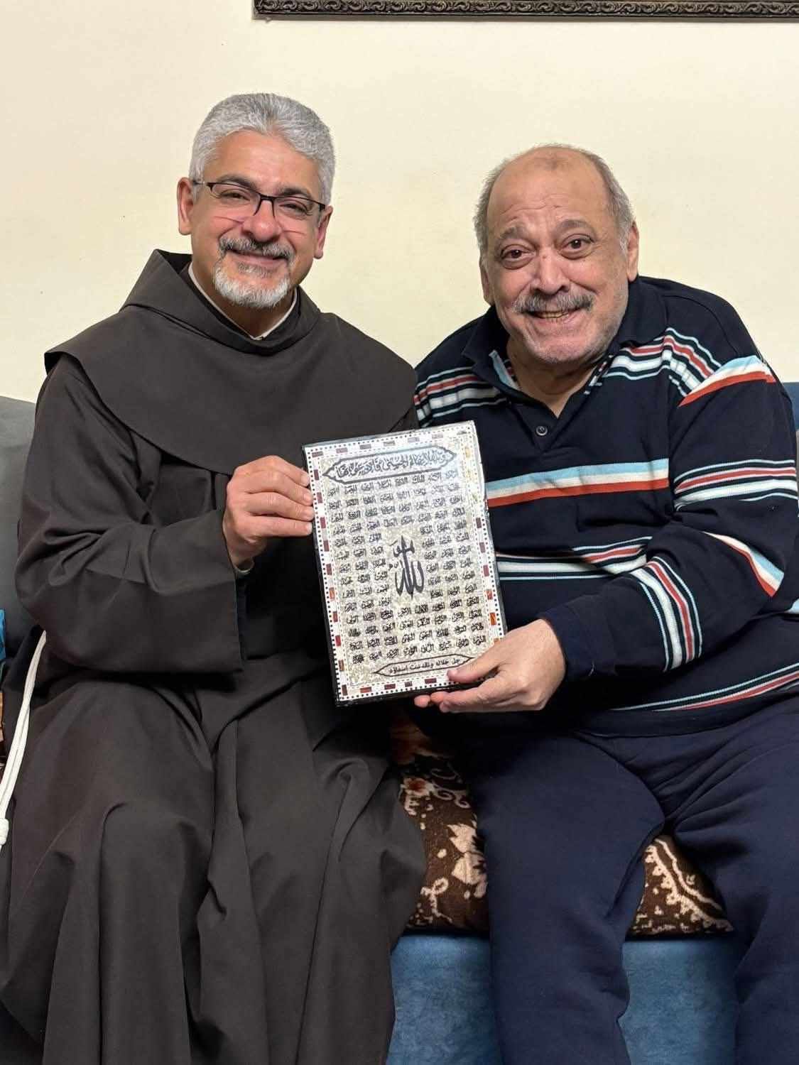 بعد أزمته الصحية.. الأب بطرس دانيال يزور ضياء الميرغني ويهديه لوحة بـ أسماء الله الحسنى - الخليج الان